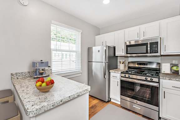 A kitchen with a granite countertop and stainless steel appliances.