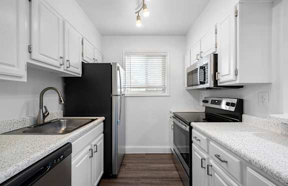 a kitchen with white cabinets and black appliances