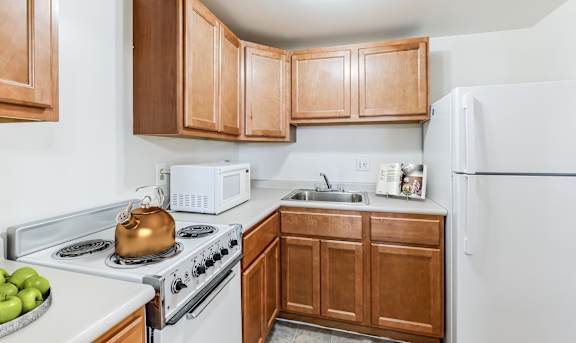 a kitchen with white appliances and wooden cabinets