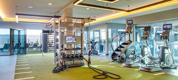 A gym with a variety of equipment including treadmills, stationary bikes, and weight machines.