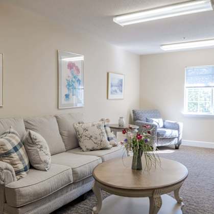 A living room with a couch, a coffee table, and two pictures on the wall.