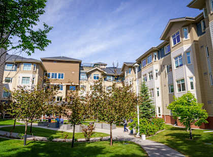 a group of people sitting on a bench in front of an apartment building