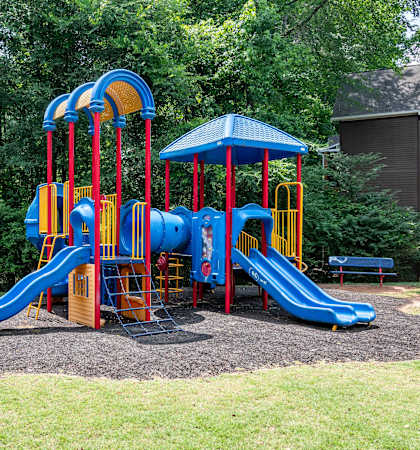 a colorful playground with slides and a picnic table