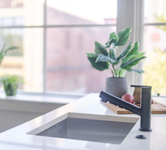 a kitchen sink in front of a window
