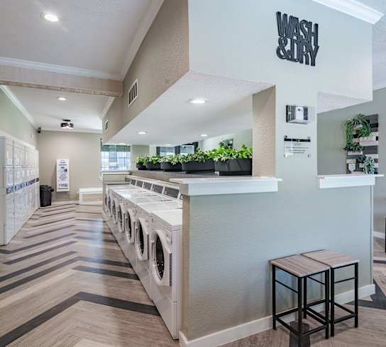 a laundry room with stools and a counter with a washer and dryer