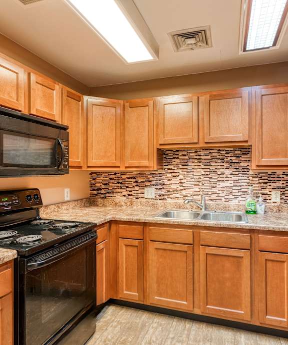 a kitchen with black appliances and wooden cabinets