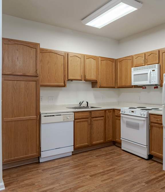 A kitchen with white cabinets and a white fridge.