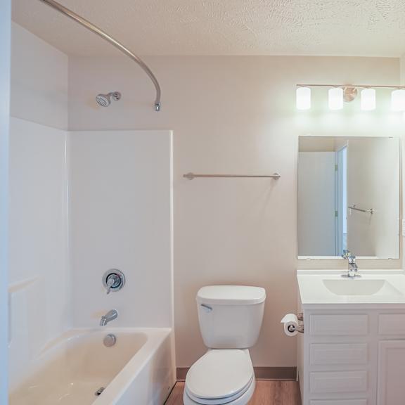 A white bathroom with a toilet, sink, and bathtub.