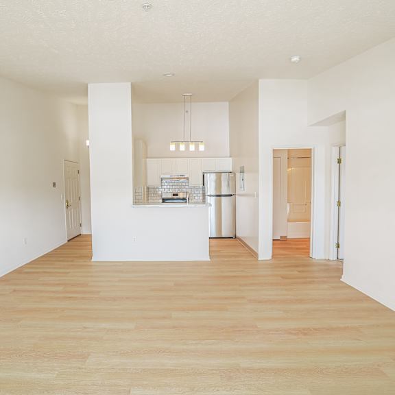 A large, empty room with wooden floors and white walls.