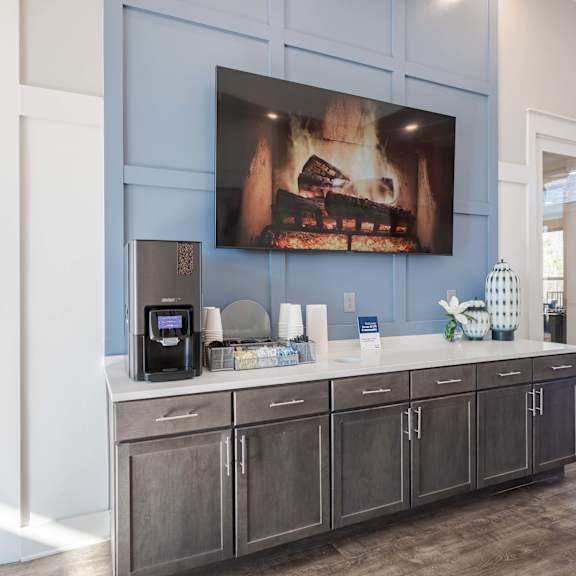 A modern kitchen with a large painting of a fireplace on the wall.