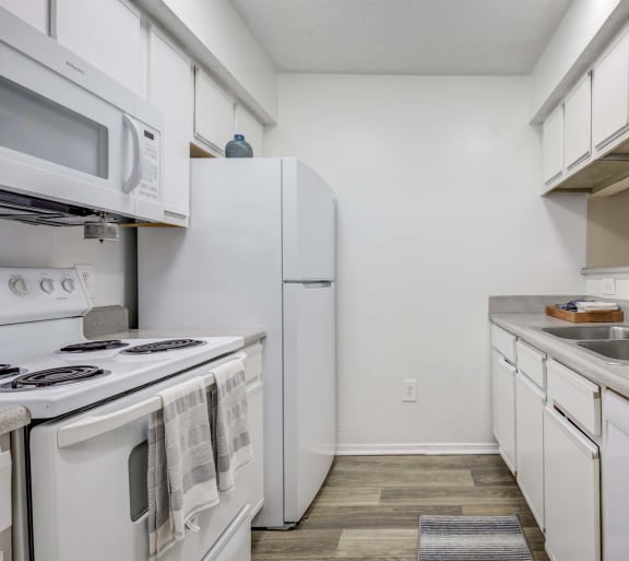 The Pearl at Highland Village Apartments and Townhomes for rent in Jackson, MS photo of a kitchen with white appliances and white cabinets