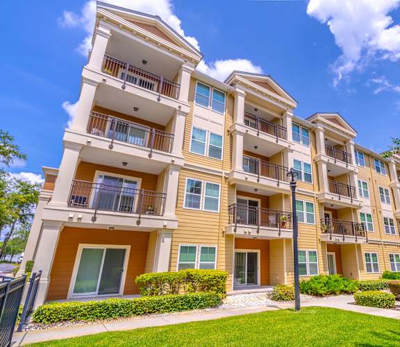A large apartment complex with multiple balconies and green lawns.