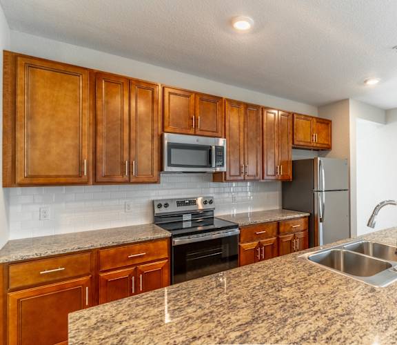 a kitchen with granite counter tops and wooden cabinets