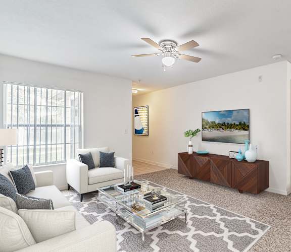 a living room with white furniture and a ceiling fan