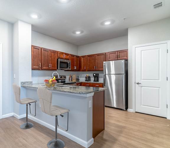 A kitchen with a white counter top and brown cabinets.