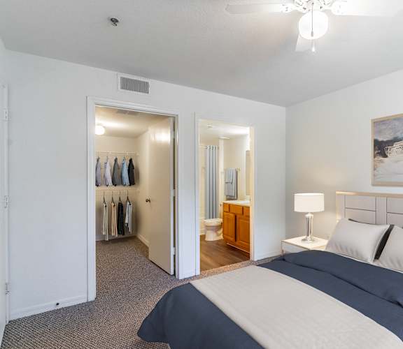 A bedroom with a large bed and a painting on the wall.