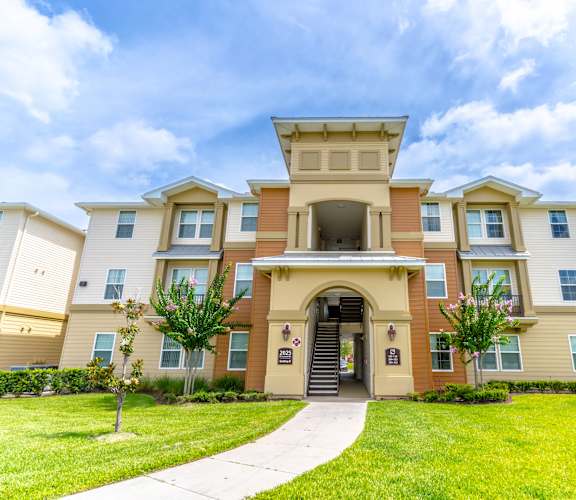 a large apartment building with a walkway leading to the front door
