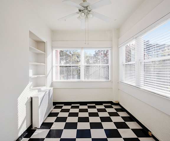 A black and white checkered floor in a room with a ceiling fan.