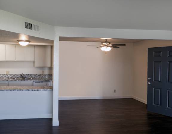 A room with a ceiling fan and a wall-mounted light fixture.