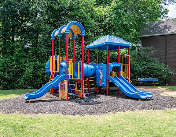 a colorful playground with slides and a picnic table