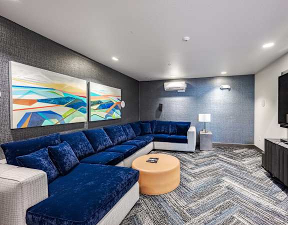 a living room with blue couches and a television