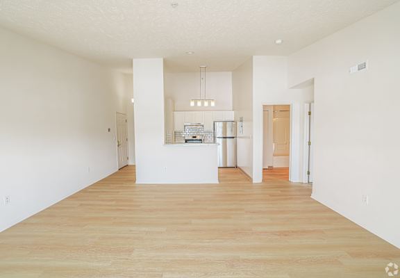 A large, empty room with wooden floors and white walls.