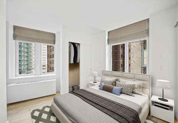 A bedroom with a large bed and a window with a view of a city. at Aria, New York, NY