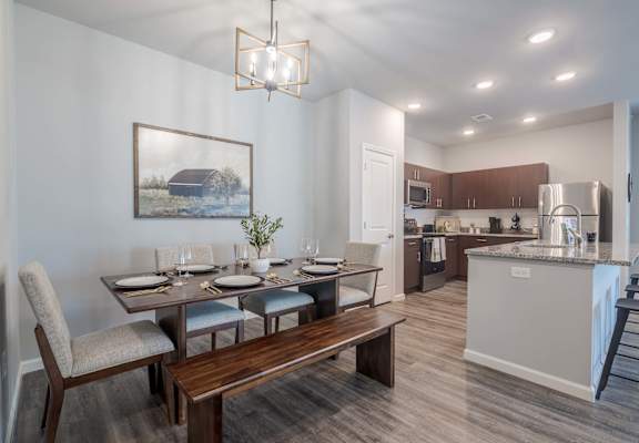 A modern kitchen with a dining table set for four.