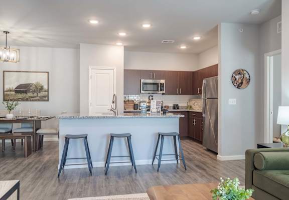 A kitchen with a bar stool and a dining table.