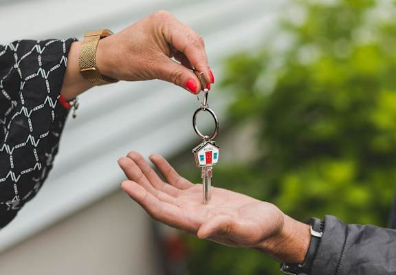 a person handing a house key to another person