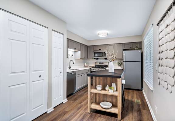 a spacious kitchen with stainless steel appliances and a wooden island