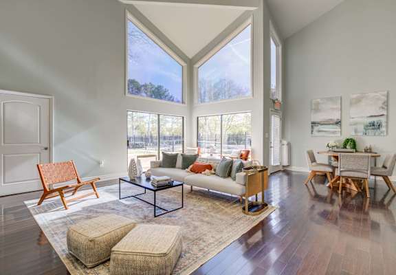 The Pearl at Highland Village Apartments and Townhomes for rent in Jackson, MS photo of a living room with large windows and a couch