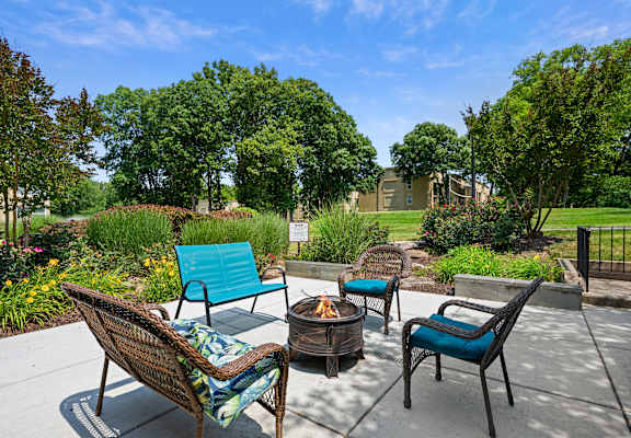 a patio with chairs and a fire pit