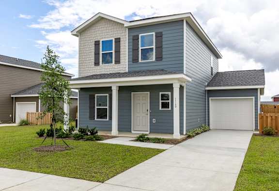 Blue house with a driveway and front sidewalk.