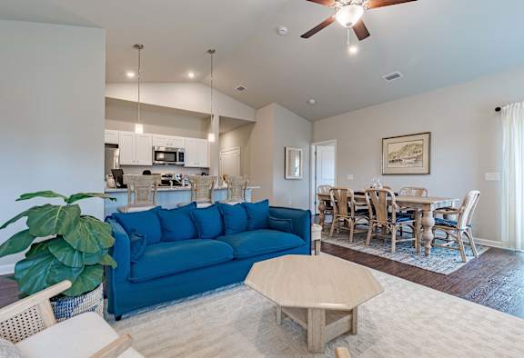 Open-concept living room with a blue couch and dining table.