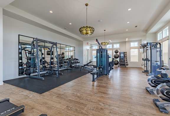 Outpost Orchard gym with weight machines and a chandelier.