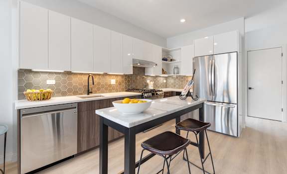 a kitchen with white cabinets and stainless steel appliances