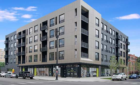 a large apartment building on the corner of a city street