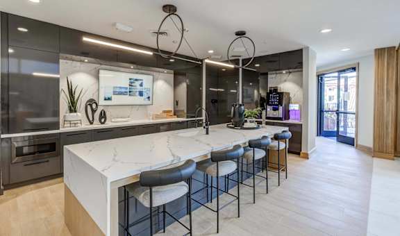 a large kitchen with a marble counter top and bar stools