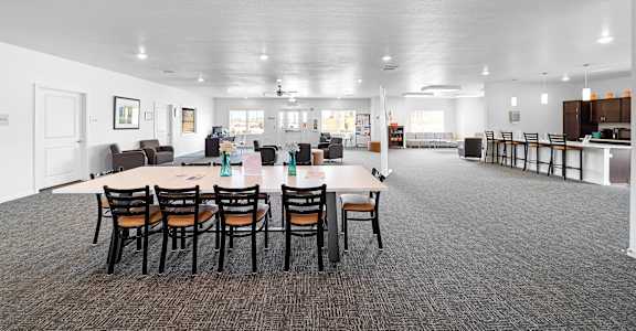 A large room with tables and chairs is shown.