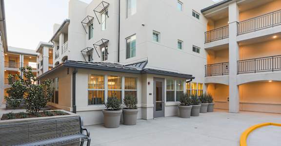 the entrance to a courtyard with a bench and an apartment building