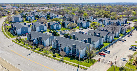 A bird's eye view of a residential area with houses and cars.