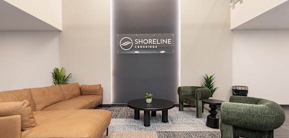 A living room with a couch, chairs, and a sign that says "SHORELINE CROSSING".