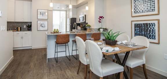 A modern kitchen with a dining table and chairs. at Liberty Square Apartments - Saltlake City, UT Apartments, Saltlake City, Utah