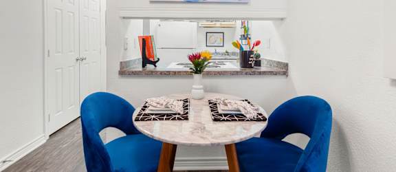 A dining room with a table and chairs.