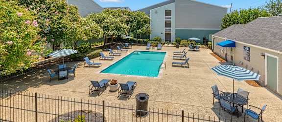 A pool surrounded by chairs and umbrellas.