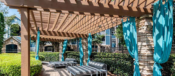 a covered patio with lounge chairs and umbrellas