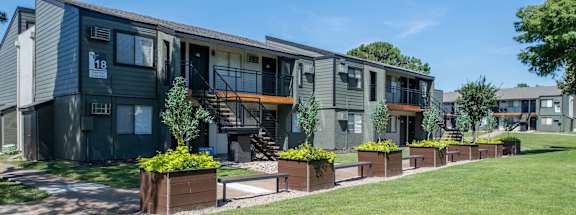 a row of modern apartments with green grass and trees
