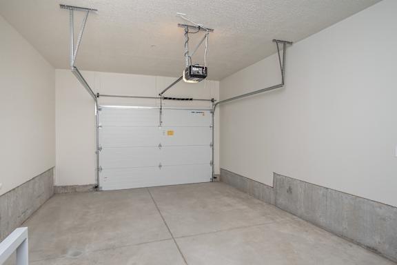 A garage with a white door and a white wall. at Liberty Square Apartments - Saltlake City, UT Apartments, Saltlake City, Utah