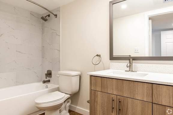 A white toilet sits next to a bathtub in a bathroom.